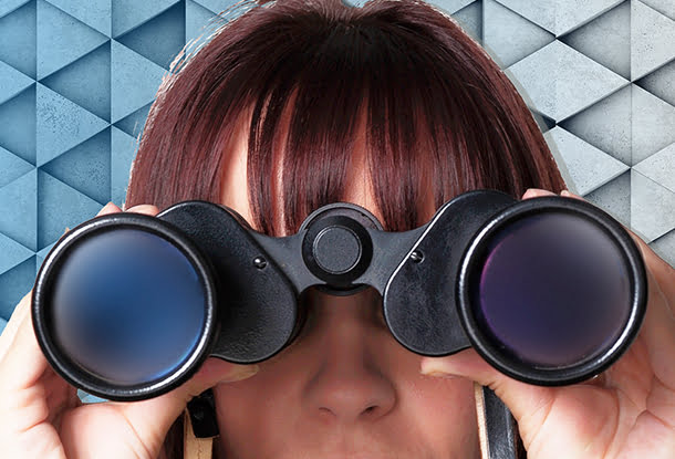 Woman with binoculars on geometric background (iStockphoto images)