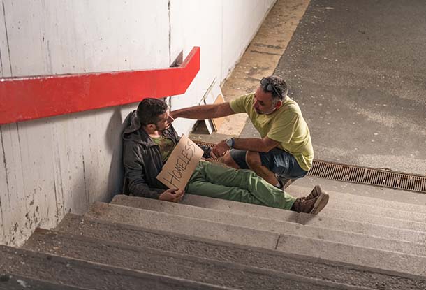 photo: compassionate man checking on homeless individual (iStockphoto)