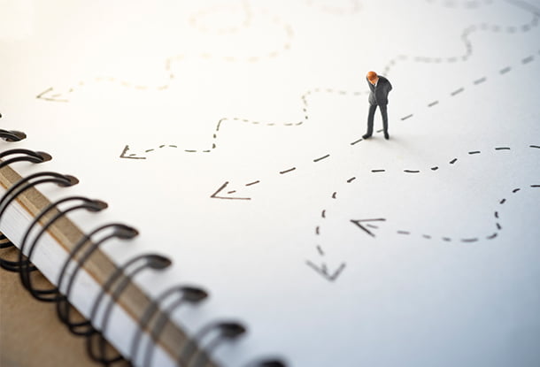 photo: miniature person looking down at lines on a notepad