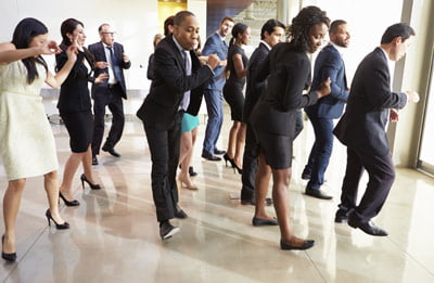 Group of people in suits line dancing